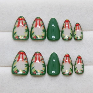 Christmas dark green almond press-on nails with red bow and gold glitter wreath design