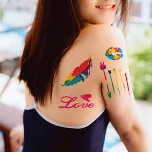 Detail of colorful waterproof temporary tattoos featuring feathers and rainbow lip prints