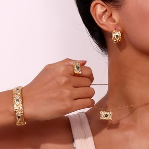 Detail of luxury gold evil eye jewelry set featuring malachite stones and zircons