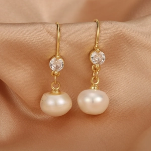 Detail of 18K gold-plated brass drop earrings with freshwater pearls and zircon stones