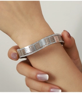 Detail of silver layered hollow bangle with sparkling crystals on model's wrist
