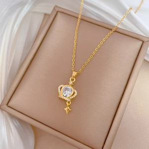 Macro view of gold crown pendant necklace with sparkling stars and crystal stones