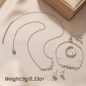 Detailed set of silver zircon necklace, bracelet, ring, and earrings on silk background