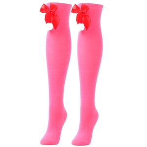 Detail of pink over-knee knit socks with decorative red bows on a clean white background