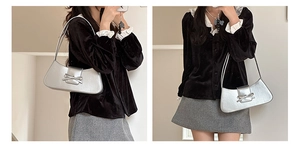 Detail shot of silver glossy shoulder bag with bow decoration and sleek texture