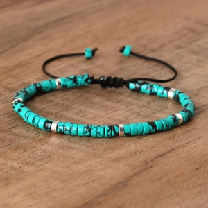 Gevlochten armband met turquoise kralen met zwarte nerven en zilveren tussenstukjes