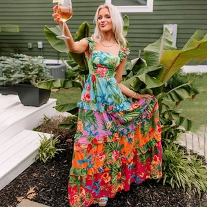 Detail of bohemian tiered floral dress featuring tropical prints and ruffled shoulder straps