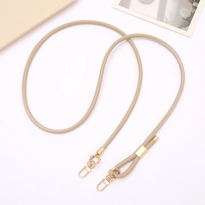 Detail of adjustable beige PU leather shoulder strap with gold metal buckle and clips