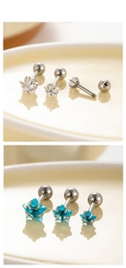 Macro detail of star zircon ear studs with screw ball backs in white and blue colors