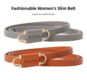 Detail of dark grey and tan leather belts with gold horseshoe buckles in a parallel layout