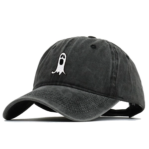 Detail of white ghost embroidery on dark grey washed cotton baseball cap texture