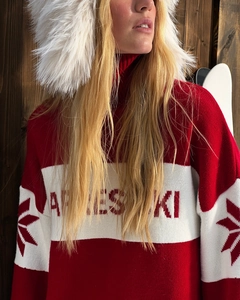 Detail of red and white knit sweater with snowflake patterns and Apres Ski text