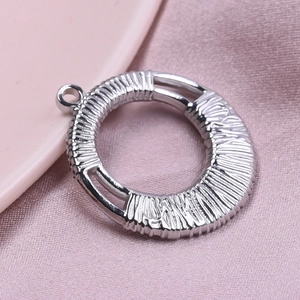 Macro shot of silver 304 stainless steel round pendant with detailed stripe texture