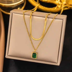 Double-layered gold snake chain necklace featuring a rectangular emerald green pendant