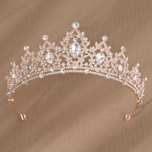 Close-up of rose gold bridal crown with crystal rhinestones on brown silk fabric
