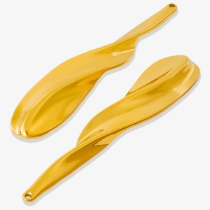 Macro shot of wavy gold-finish stainless steel pendants with smooth reflective surfaces