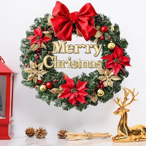 Christmas wreath with red velvet bows and gold ornaments featuring Merry Christmas sign