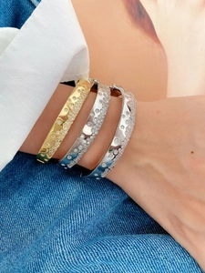 Gros plan de bracelets ouverts en or et argent sertis de zircons cubiques scintillants