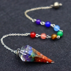 Detailed view of handmade 7 chakra stone beads on a silver chain with a resin pendulum