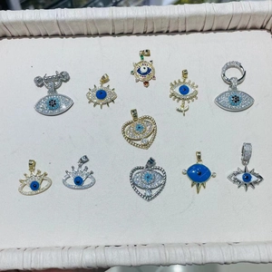 Sammlung von Evil-Eye-Anhängern aus Gold und Silber mit Strasssteinen auf einem Display