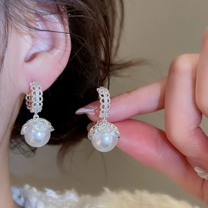 Detailed close-up of a French vintage pearl earring with intricate silver filigree and zircon