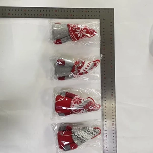Close-up of four knitted Christmas gnomes in festive red and grey with hanging loops