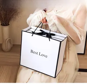 Minimalist white gift bag with black trim, ribbon bow, and Best Love text for presents