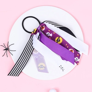 Close-up of Halloween ribbon hair tie with pumpkin and bat prints on a white plate