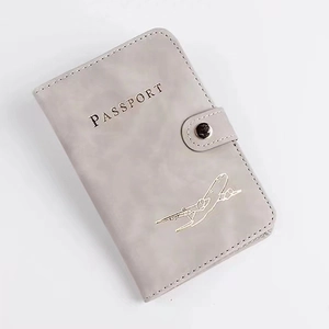 Gray PU leather RFID passport holder with snap button and golden embossed airplane logo