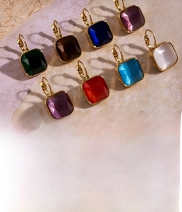 Détail de boucles d'oreilles carrées en zircone de différentes couleurs plaquées or
