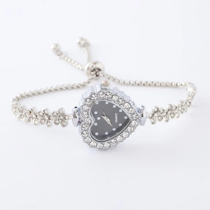 Detail shot of a silver heart-shaped watch with crystal bezel and flower chain strap