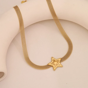 Macro detail of golden mesh chain necklace with 3D star pendant in stainless steel