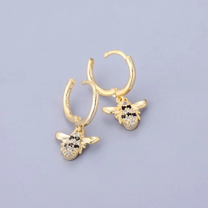 Macro shot of 18K gold bee drop earrings featuring black and white cubic zirconia and S925 stamp
