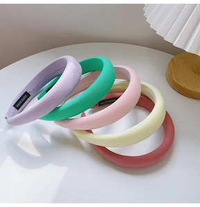 Close-up of thick candy-colored sponge headbands with handmade labels in soft lighting