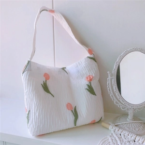 Gros plan détaillé du motif tulipe rose sur le sac cabas en tissu bulle texturé blanc
