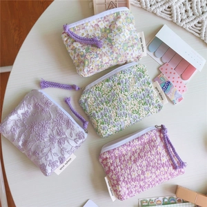 Gros plan de quatre mini pochettes en tissu à fleurs avec fermetures en corde aux tons pastels