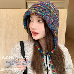 Close-up of rainbow knit trapper hat with handmade braided straps and cozy earflaps