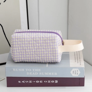Macro detail of quilted purple checkered makeup bag showing fabric texture and sturdy handle