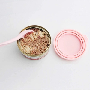 Detailed view of pink silicone pet can lid with universal multi-fit rings and a mixing spoon