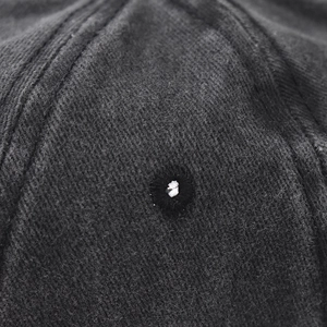Detailed macro view of the embroidered eyelet and twill fabric texture on a washed baseball cap