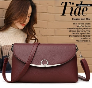 Close-up of wine red leather crossbody bag featuring a heart-shaped silver metal buckle