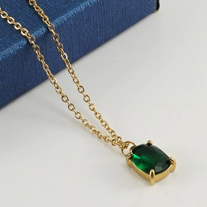 Collier en acier inoxydable plaqué or 18K avec pendentif ovale en zircon vert sur fond blanc