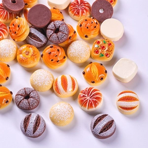Detailed macro shot of assorted miniature resin food charms including tiny donuts and breads