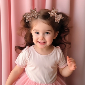 Detail of glitter rose gold sequin bow hair clips worn on child's hair for safe styling