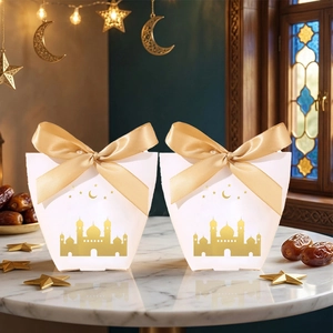 Macro shot of gold foil castle and moon on white gift box with champagne satin ribbon bow