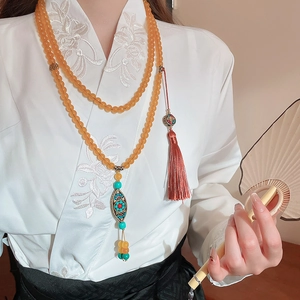 Macro detail of vintage beaded necklace with amber crystal beads and silk tassel decoration