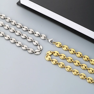 Close-up of gold and silver coffee bean pig nose link chains with lobster clasp details