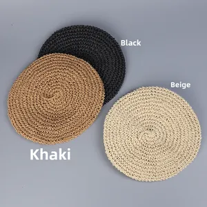 Flat lay of woven straw beret hats in black, beige and khaki colors with detail texture