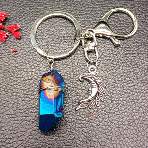 Detail of natural blue crystal pendant and silver crescent moon on key ring