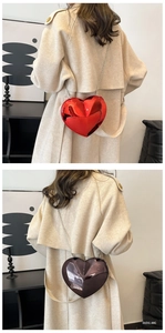 Detail of heart-shaped acrylic evening bags with glossy mirror finish and metal chains